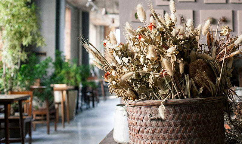 Tørket gress og frøkapsler i en vase.